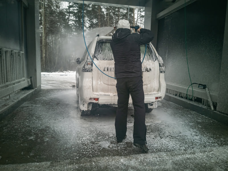 53714881-man-worker-washing-big-offroad-car-on-a-car-wash-in-winter