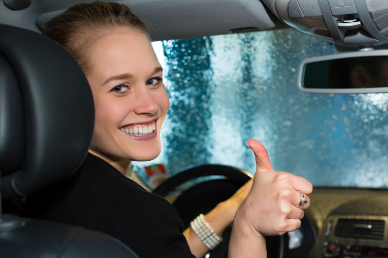 7136765-young-woman-drives-car-in-wash-station